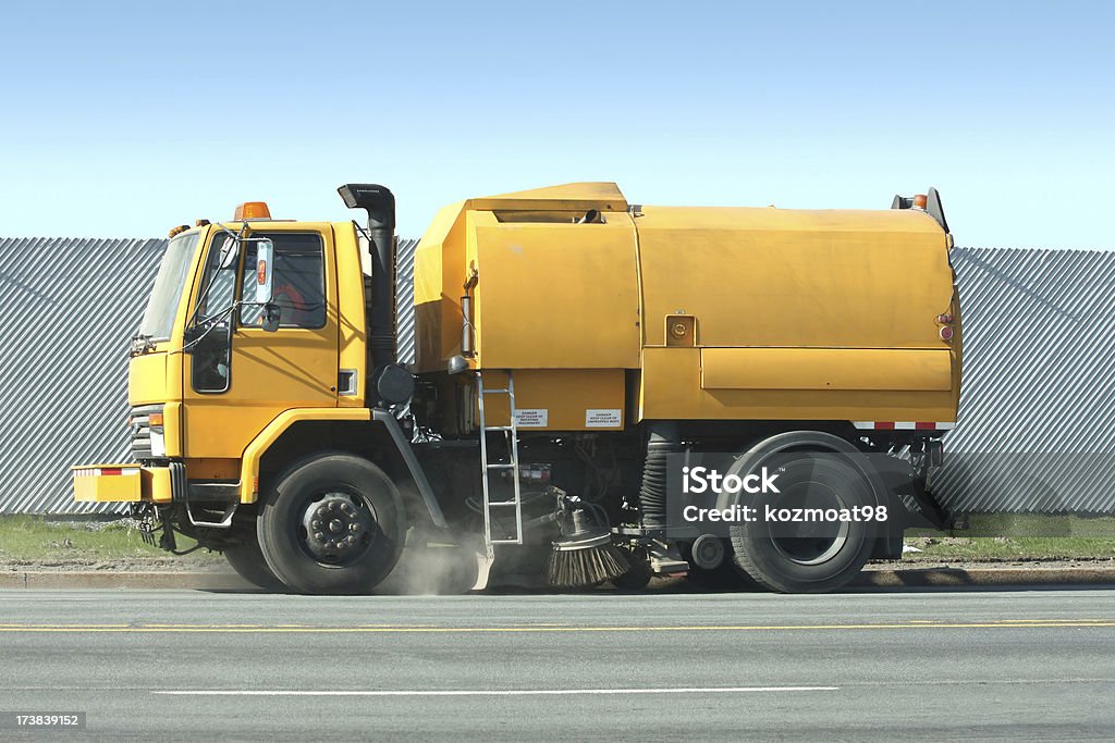 Street Sweeper Road sweeper moving slowly as it sweeps and vacuums up road debris on a city street. Side view, early morning. Street Sweeper Stock Photo