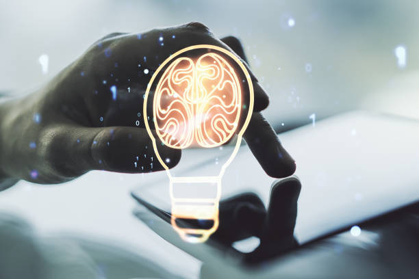 istock Creative light bulb with human brain hologram and hand working with a digital tablet on background, artificial Intelligence and neural networks concept. Multiexposure 1738393359