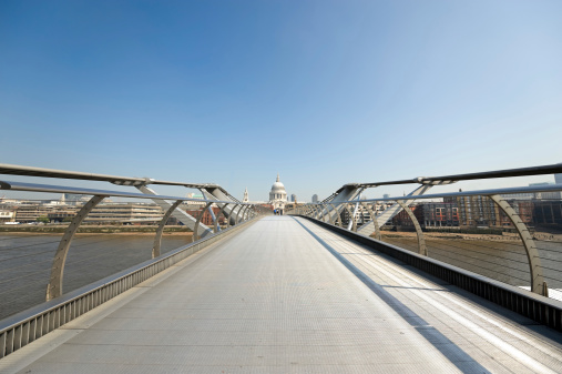 Millenium Bridge, crossing Thames River at St Paul's Cathedral, with its iconic dome clearly visible.