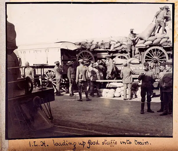 "Vintage  photograph showing British Soldier of the Imperial Light Horse loading food stuffs into a train. South Africa, during the Boer War in 1900."