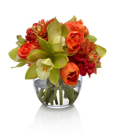 A rose, dahlia and orchid bouquet in a round glass bowl. The arrangement has a path to delete the reflection if desired.  Photographed on a bright white background. Extremely high quality faux flowers. 
