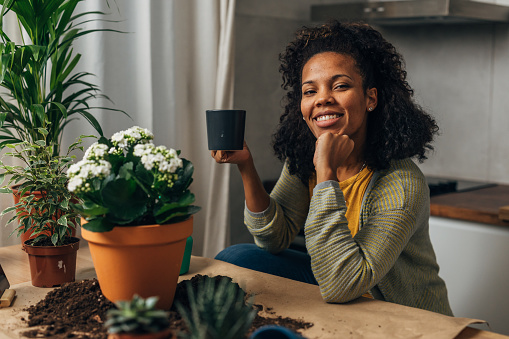 A woman is satisfied after replanting her houseplants