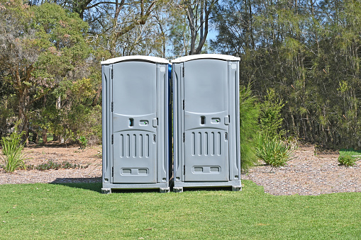Two mobile or portable toilets in a park