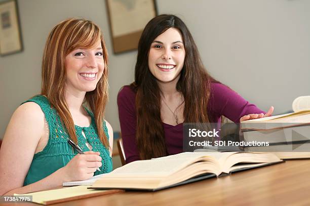 Due Sorridente Donna Studenti Universitari Che Studiano In Libreria - Fotografie stock e altre immagini di Adulto