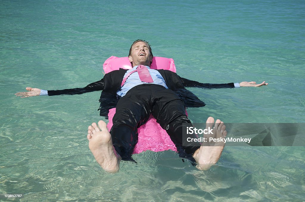 Flutuante Empresário relaxante em uma rosa Colchão de Ar - Royalty-free Fato Foto de stock