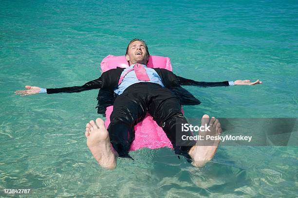Бизнесмен Расслабляющий Плавающий На Розовом Матрац Для Бассейна — стоковые фотографии и другие картинки Костюм