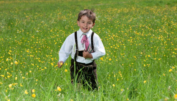 Three year old boy in Lederhosen running through the meadow. Nikon D3X. Converted from RAW. 100% crop.