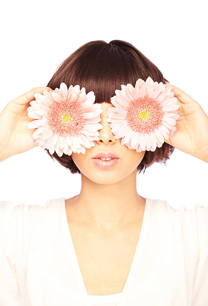 istock Brunette Covering Her Eyes with Gerbera Daisies 173843296