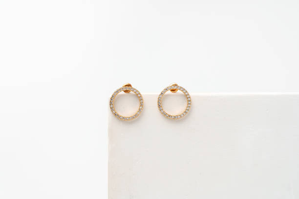 istock Golden earrings on display on white background 1738445847
