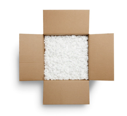 Open cardboard box filled with styrofoam peanuts. Shot from directly above.  Isolated on white background.