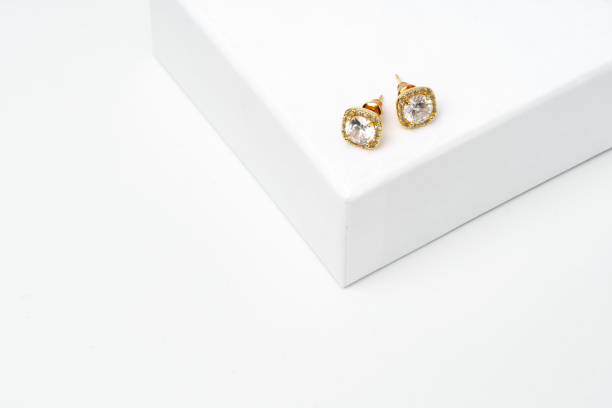istock Golden earrings on display on white background 1738446379