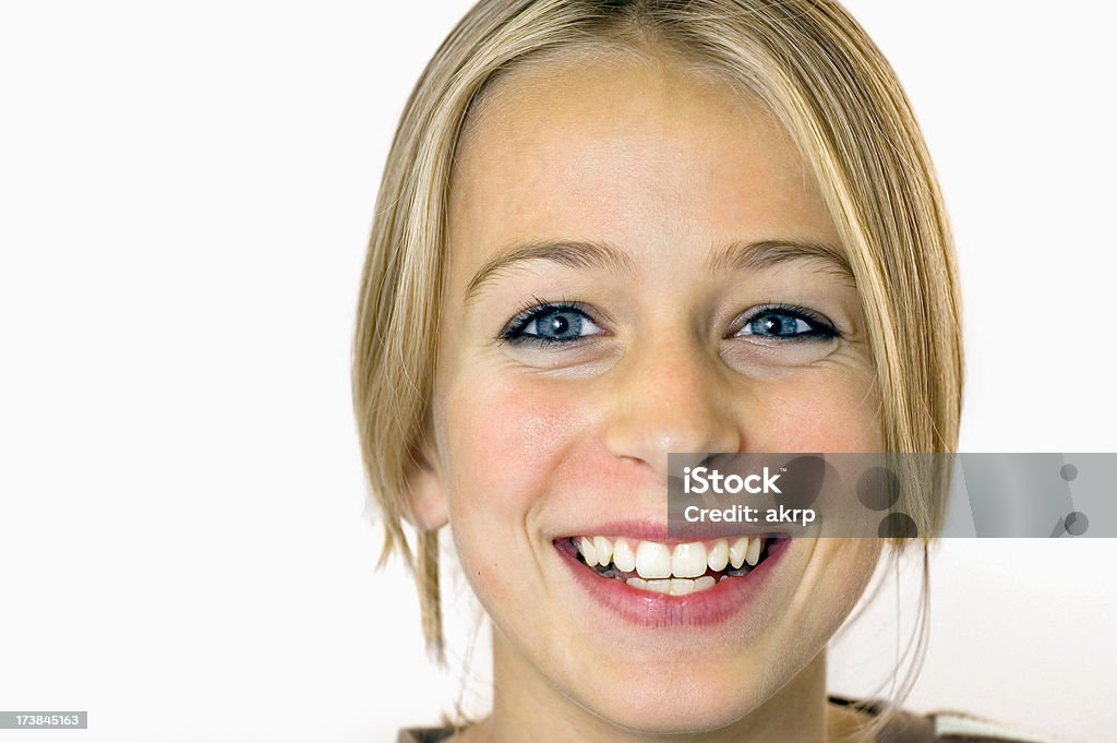 Pretty teenage girl laughing Closeup of a pretty blond girl with blue eyes laughing into the camera. Studio shot. Isolated on white. Copy space. 14-15 Years Stock Photo