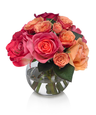 A beautiful bouquet of peach and pink spice roses in a glass bubble bowl with reflection. The image has an embedded path to delete the reflection if desired.  Photographed on a bright white background. Extremely high quality faux flowers.