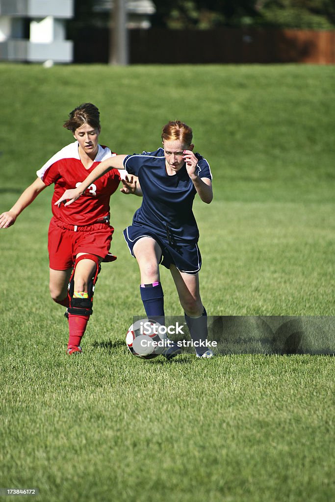 Due giovani donne calciatori lotta per la sfera con spazio per il testo - Foto stock royalty-free di Ginocchiera - Tutore