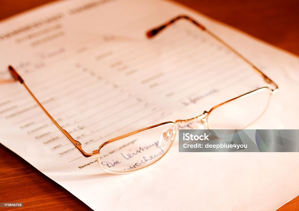 attestation- glasses on document close up of a glasses on a german high school attestation Report Card Stock Photo