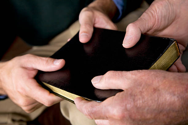 istock Closeup of Two men holding a Black Bible 173846992