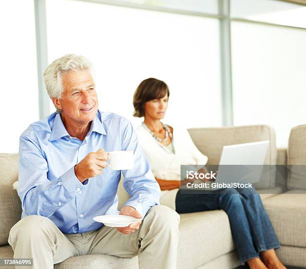 Photo libre de droit de Homme Dâge Mûr Boire Du Café Et À Laide Dun Ordinateur Portable Femme banque d'images et plus d'images libres de droit de Femmes