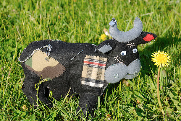 Homemade punk  felt cow on grass