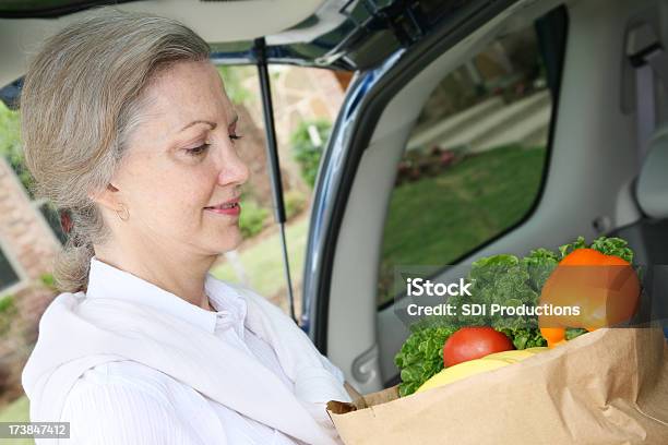 Photo libre de droit de Femme Âgée Tenant Des Légumes Épicerie Dans Coffre De Voiture banque d'images et plus d'images libres de droit de Adulte