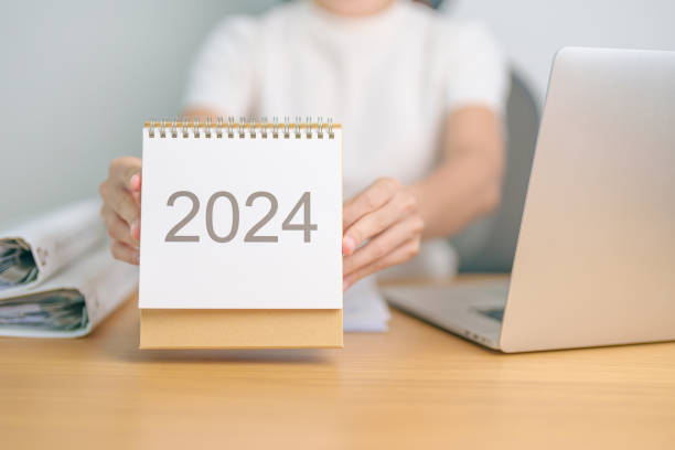 istock 2024 Year Calendar on table with business woman using laptop computer. countdown, Happy New Year, Resolution, Goals, Plan,  Action, Mission and financial Concept 1738474839