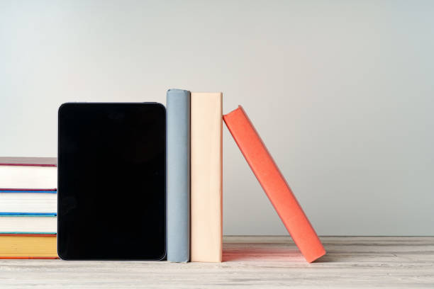 istock Digital tablet with a stack of books on gray background 1738477018