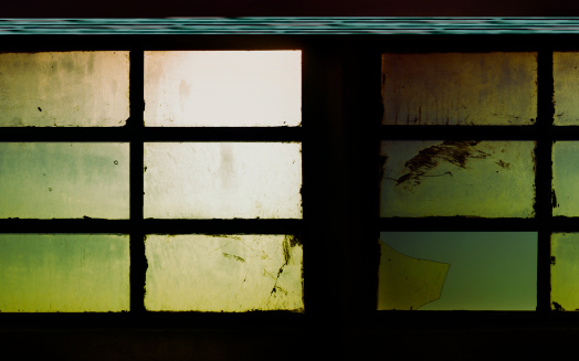 Demolished window with broken glass and stone.