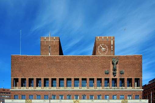 Oslo, Norway: Oslo City Hall (Oslo rådhus) - built 1931–1950 according to drawings by the architects Arnstein Arneberg and Magnus Poulsson. Located in the center of Oslo on the north side of Pipervika, the south façade faces Rådhusplassen, the town hall piers (Rådhusbryggene) and the Honnørbryggen pier by the Oslo Fjord. It is the venue for the yearly awarding of the Nobel Peace Prize.