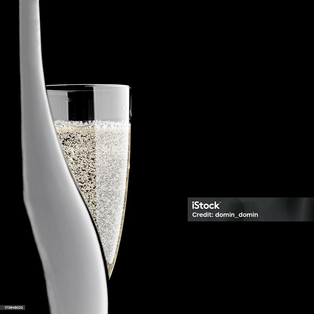 Close-up of champagne bottle and glass, isolated on black background Close-up of champagne bottle and champagne glass, isolated on black background. Studio shot, copy space. Champagne Stock Photo