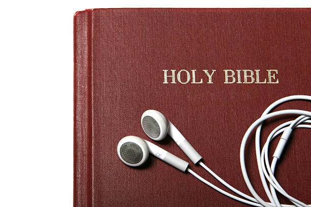 bible with earbuds -podcast of religious service, sermon stock photo