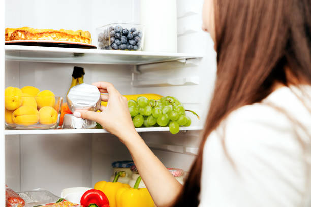 istock Hand taking, picks up camembert or brie cheese out of open refrigerator, fridge 1738493008
