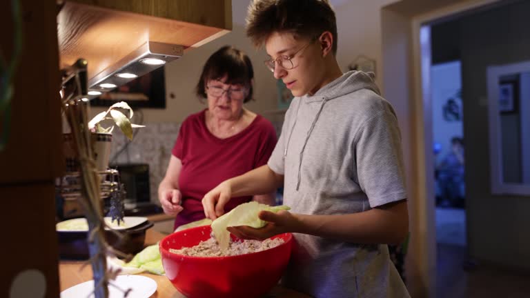 Grandmother and grandsons making traditional Cabbage Rolls for Christmas