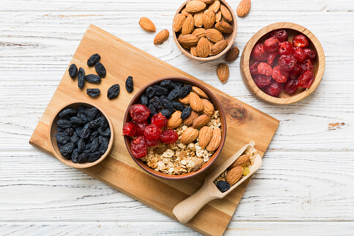 Cooking a wholesome breakfast. Granola with Various dried fruits and nuts in a bowl. The concept of a healthy dessert. Flat lay, top view with copy space.