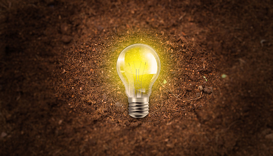Glowing Light Bulb on Soil Background. Save Erath and Planet, Sustainable Environment, Saving Energy and Ecological Friendly Concept