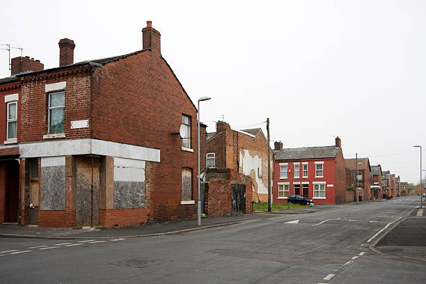 Recession in the city Streets of row houses / terraced houses in an inner city area. Many are boarded up and in disrepair. This is Moss Side, Manchester, UK. run down neighborhood stock pictures, royalty-free photos & images