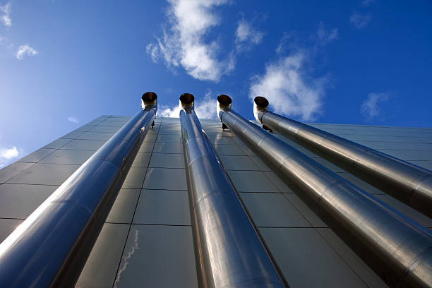 pilha de combustão exterior de um edifício moderno contra céu azul - flue gas imagens e fotografias de stock