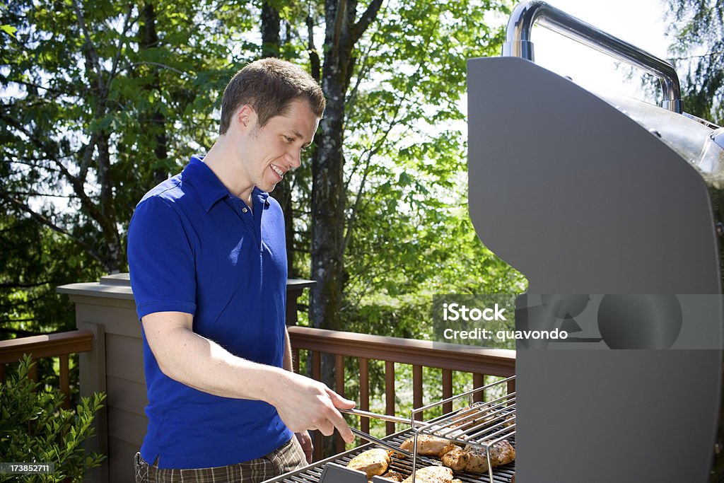 Pollo BBQ Grill, amichevole giovane uomo sulla terrazza all'aperto - Foto stock royalty-free di Griglia per barbecue