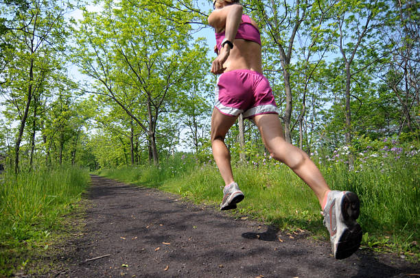 Woman Runner on Wooded Trail stock photo