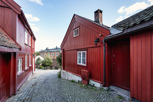 Oslo Old Town Damstredet, Typical old red wooden houses in the old town village in Damstredet Cobblestone Street in Oslo under blue summer sky. One of the oldest streets in the historic center of Oslo, Capital of Norway. Damstredet, Oslo, Norway, Scandinavia