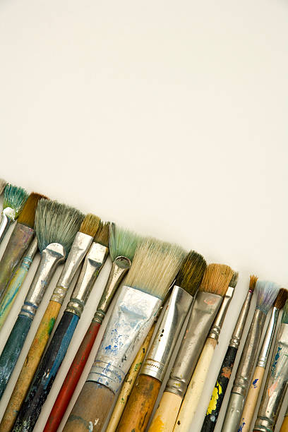 istock Well used artists paintbrushes on white paper with copy space 173854464