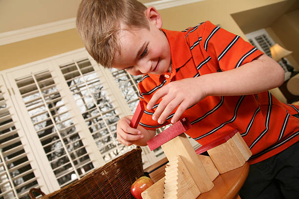 istock Preschool boy carefully placing block on top 173855059