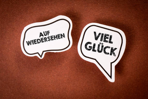 Goodbye and Good Luck in German. Text on speech bubbles. Brown background.