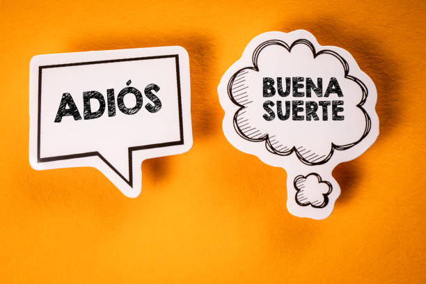 istock Goodbye and Good Luck in Spanish. Text on speech bubbles. Yellow background 1738552425