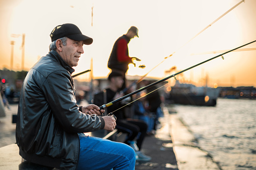 istanbul, turkey - may 2023: man fishing on a dock