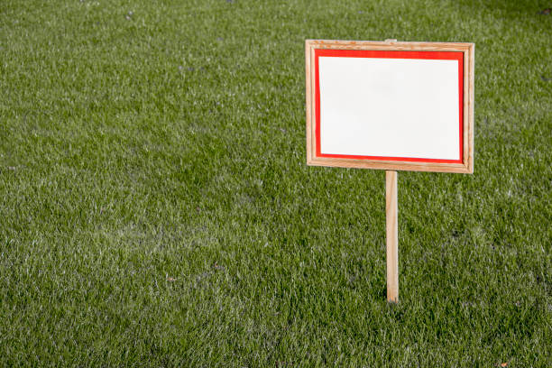 istock Pointer sign on a lawn with green grass. Banner mockup with place for text. 1738568485