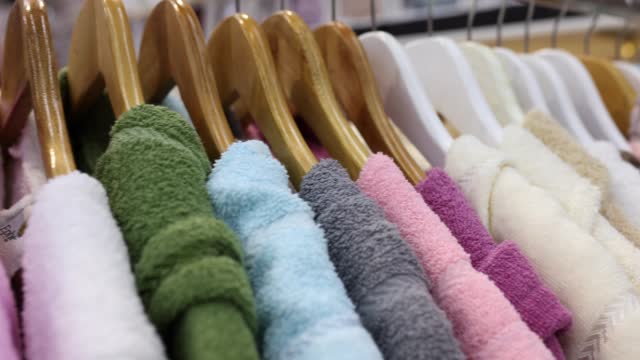 Colourful terry robes hang on hangers in shopping department