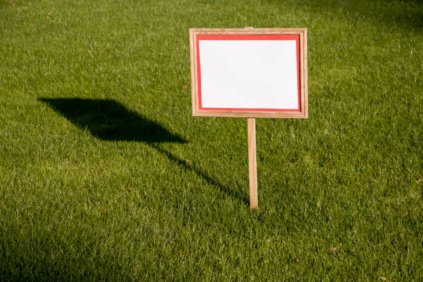 istock Pointer sign on a lawn with green grass. Banner mockup with place for text. 1738580253