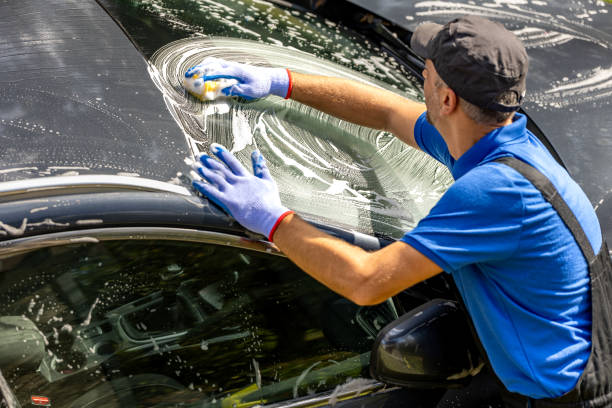 istock High angle view of man worker washing car windshield with sponge. 1738582503