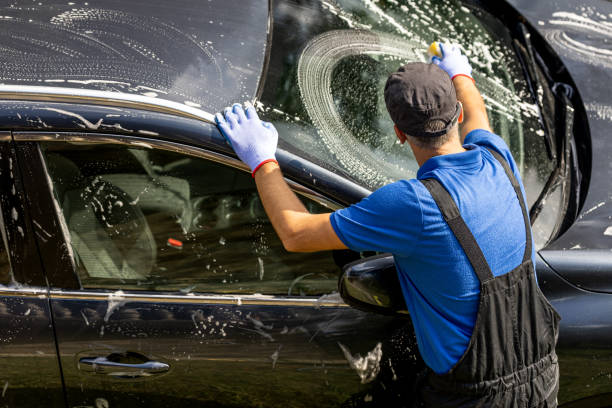 istock Professional car wash worker cleaning windshield with sponge 1738583039