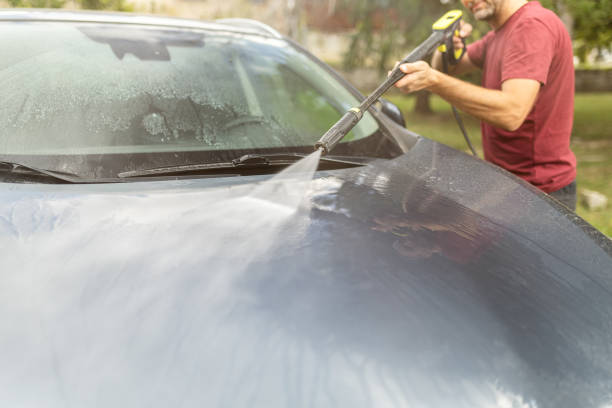 istock Man washing his car in the backyard by using water pressure washer 1738585970