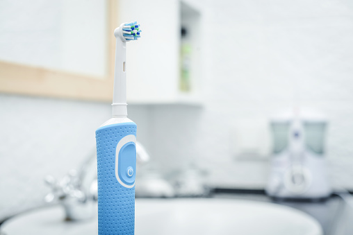 Electric toothbrush on table in contemporary bathroom closeup